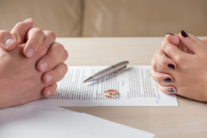 Two clasp hands on table